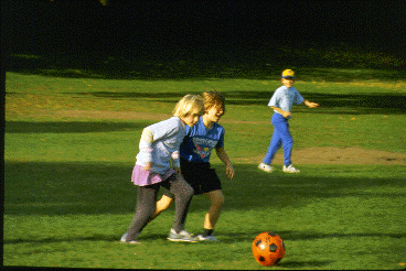 Two human children play soccer.