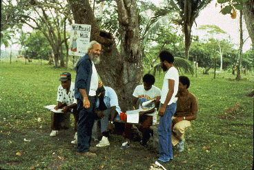 A group of farmers sit on a bench while they  sign the conservation agreement.